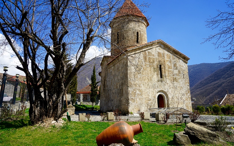 Església medieval de pedra a Geòrgia envoltada de natura i muntanyes del Caucas