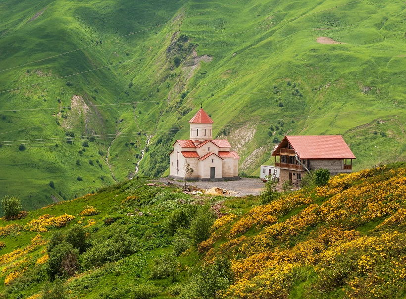 Església de muntanya a Geòrgia envoltada de prats verds al Caucas